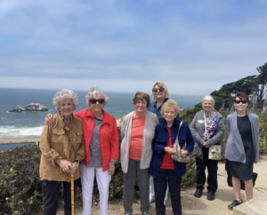 People standing on the sidewalk in front of the beach