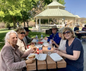 Seniors eating at a picnic bench