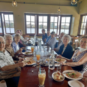 Group of senior sitting at a dining room table eating dinner
