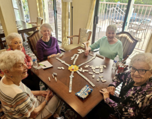 Seniors playing a table game with Dominos