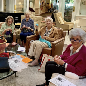 Seniors sitting down and knitting