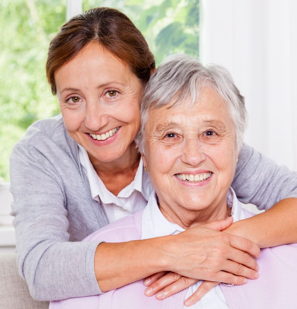 Lady with her mother hugging from behind
